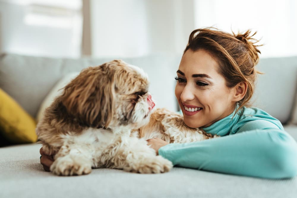 Woman sitting with dog on couch